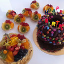 Schokomarmorguglehupf (rechts) mit Smarties - der beliebteste Kuchen für Kindergeburtstage. Ergänzt durch einen Mehrfruchtkuchen (links) sowie Mini-Frucht-Tartelettes 