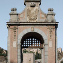 PUENTE DE ALCÁNTARA. Arco de entrada al puente, 1721. Construido en ladrillo y piedra, decorado por guirnaldas de flores y frutas, con tarjetas que portan inscripciones conmemorativas y las armas de la ciudad.