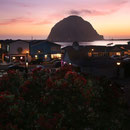 Morro Rock and the harbour at twilight.