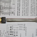 der Drehgeber links wird an ein 6 poliges Flachbandkabel und Platinenstecker montiert