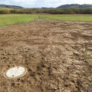 Die Beete sind wieder vollständig mit Erde überdeckt. Ist im nächsten Jahr Gras darüber gewachsen, ist von dem Eingriff bis auf die Kontrollschächte nichts mehr zu sehen.