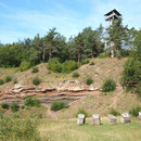 Auf dem Weg zum Booser Eifelturm kommt man an Zeugen früheren Abbaus des Vulkangesteins vorbei. Im Lavaband dieser Grube sind noch mehrere Lavabomben eingeschlossen.