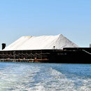 Eine der riesigen Salzschuten, die das frisach gewonnene Salz aus der (flachen) Bucht zu einenm Tiefwasserhafen bringt.