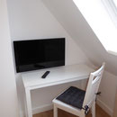 Konsolentisch und LED-TV im Dachgeschoss-Schlafzimmer