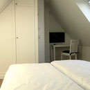 Schlafzimmer im Dachgeschoss, hier Einbauschrank und LED-TV 