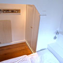 Blick vom Bett in den kleinen Schlafraum mit hübschen Einbauten im friesischen Landhausstil