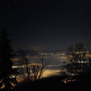 Die Lichter des Mittellandes drücken durch die leichte Nebeldecke