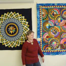 Frau Kielenbeck in der Ausstellung vor zwei Quilts
