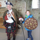 At Urquhart Castle, Loch Ness with a traditionally dressed highlander from the 1700's with traditional weapons.