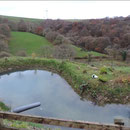 View over the mill pond and valley to wind turbines on the opposite ridge