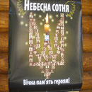 Neben dem Eingang zur Holzkirche hängt ein Bild der "Himmlischen Hundertschaft". Die Fotos der Toten bilden zusammen den Dreizack - ein nationales Symbol der Ukraine. Foto: Stefan Korinth