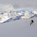 Ein wenig tiefer wird der Schnee besser und Simon kann's krachen lassen. Hinten die Berge des Riesen-Gebirges Jotunheimen.