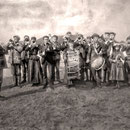L'abbé Louis-Émilien Boily et Lucien Comettant, la fanfare, L'abbé Boily est né à St-Agnès dans Charlevoix en 1866.  Il fut curé de Baie-Ste-Claire de 1898 à 1900. Tois des filles de Lucien Comettant jouent, au triangle, à la grosse caisse et au cornet.