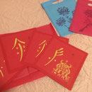 Caractères nüshu à la feuille d'or sur carré de papier Canson rouge