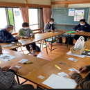 集会所にて地域民生委員の方、社協の職員、土佐市立高石小学校教頭先生、高石地区自治会長、高石保育園園長先生など総勢11名で種の梱包作業