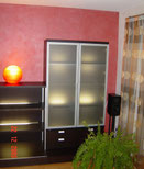 Gestaltung mit Lesando Lehmputz farbig gewachst, Laminatboden.  Wohnzimmerwand mit Metallic-Lasur im kräftigen Rotton beschichtet.
