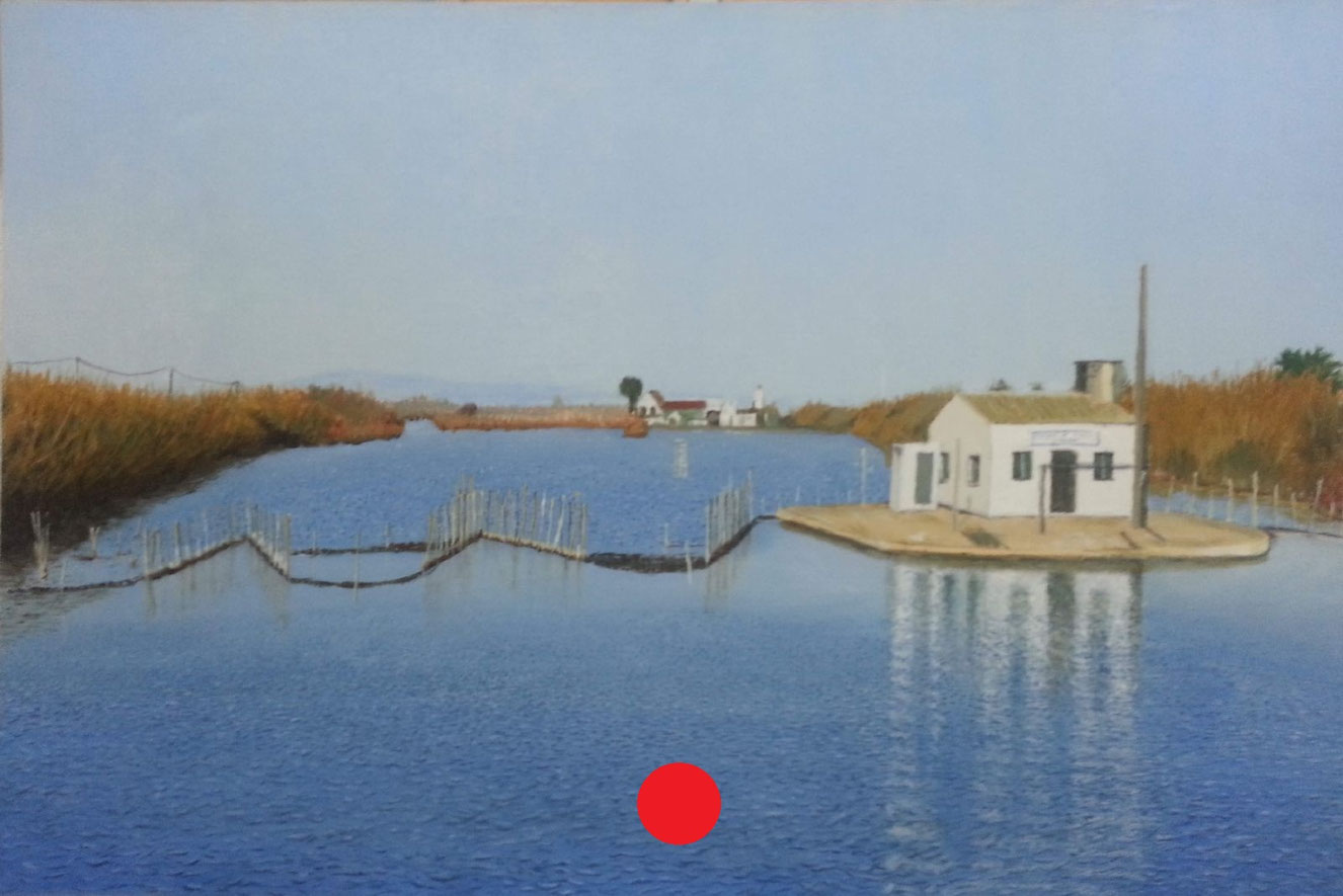 Casita blanca junto a un canal amplio, reflejada en el agua, con cañas verticales y vegetación en ambas orillas bajo cielo despejado.