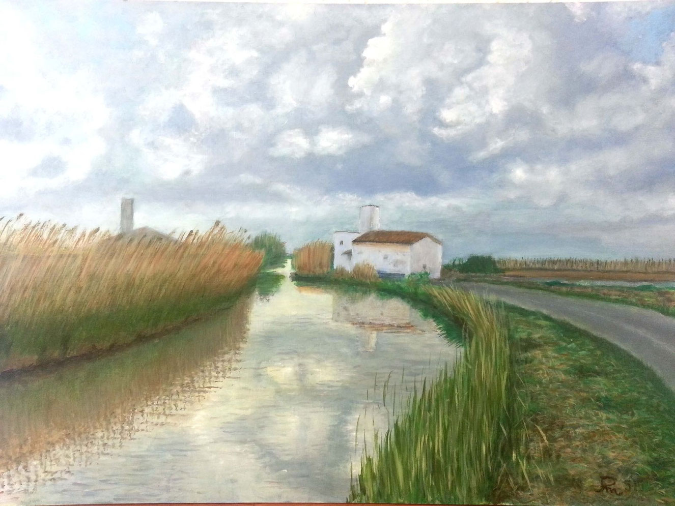 Canal de la Albufera con casa blanca, carrizo y cielo cubierto de nubes de tormenta reflejadas en el agua.