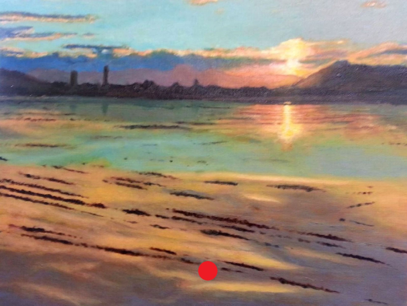 Atardecer sobre aguas tranquilas con reflejos cálidos, silueta lejana de edificaciones y surcos de barro en primer plano.