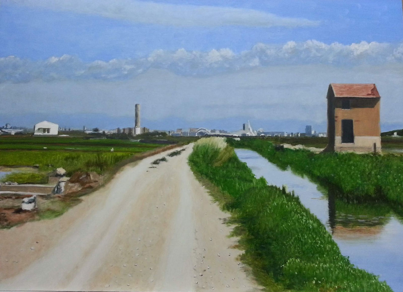 Casa de motores junto a una acequia, camino de tierra, vegetación alta y la ciudad de Valencia al fondo con la Ciudad de las Ciencias destacando.