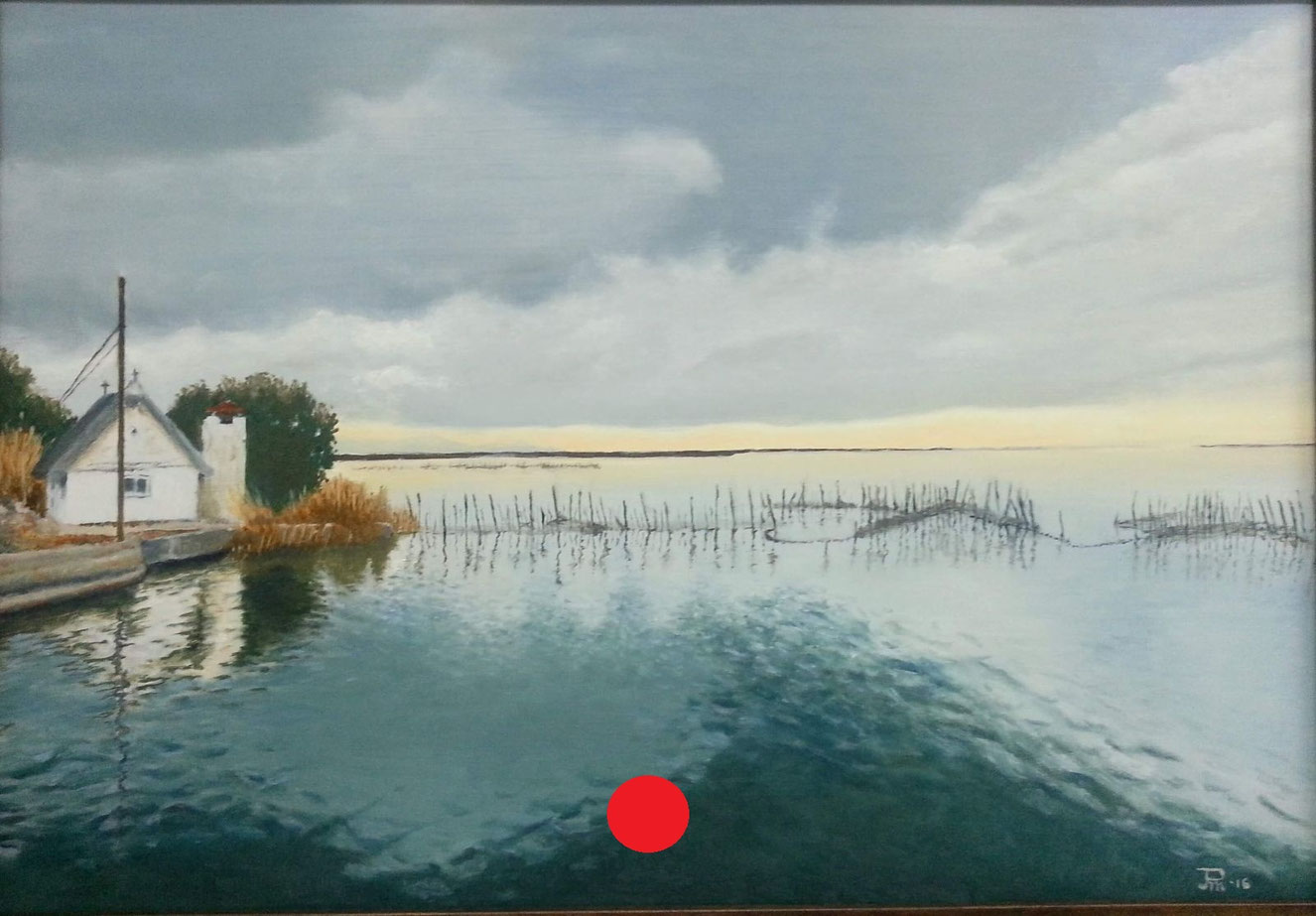 Barraca blanca junto al lago, rodeada de vegetación, con agua en calma y cielo nublado iluminado suavemente en el horizonte.