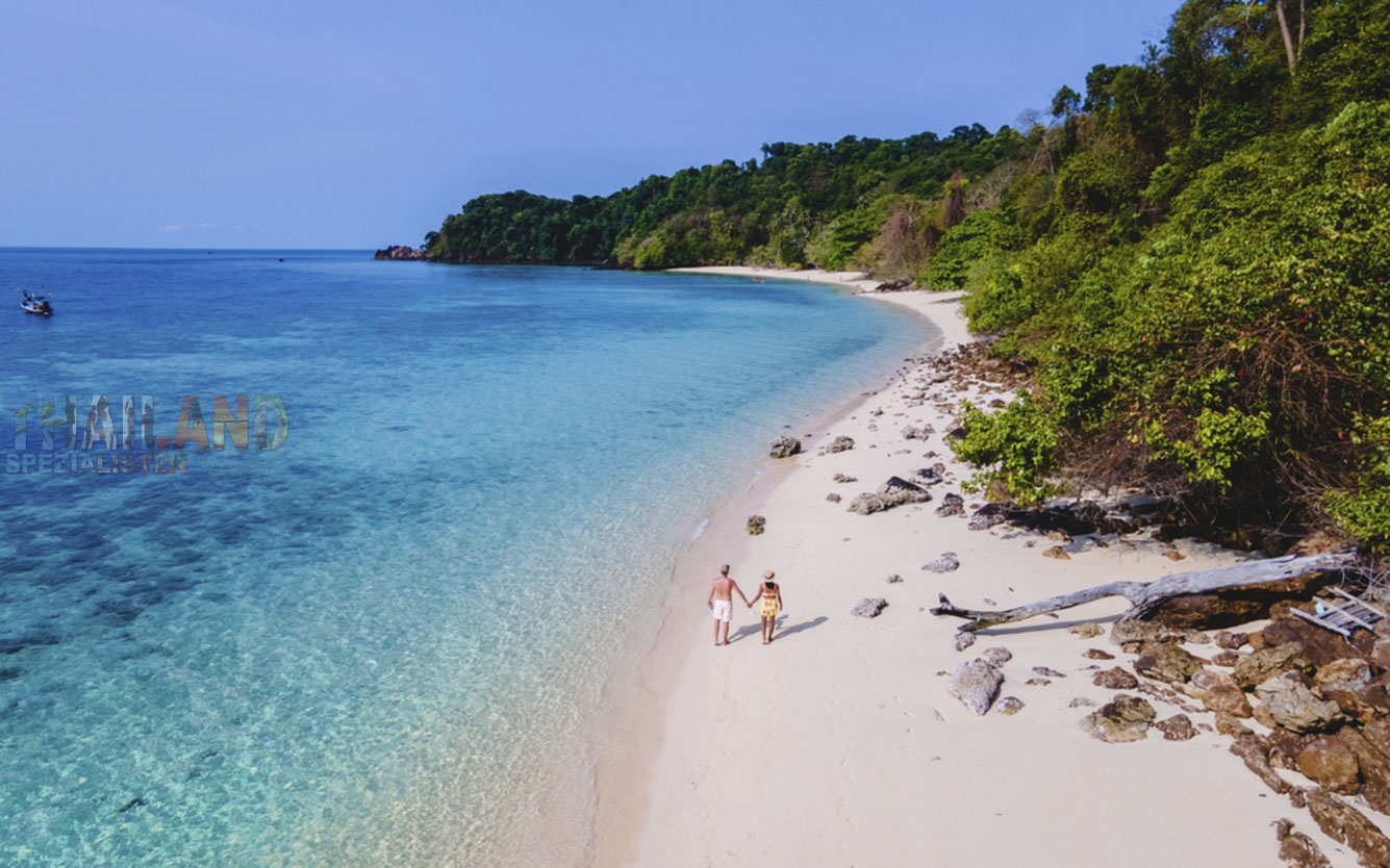 Paar geht Hand in Hand auf Koh Kradan spazieren