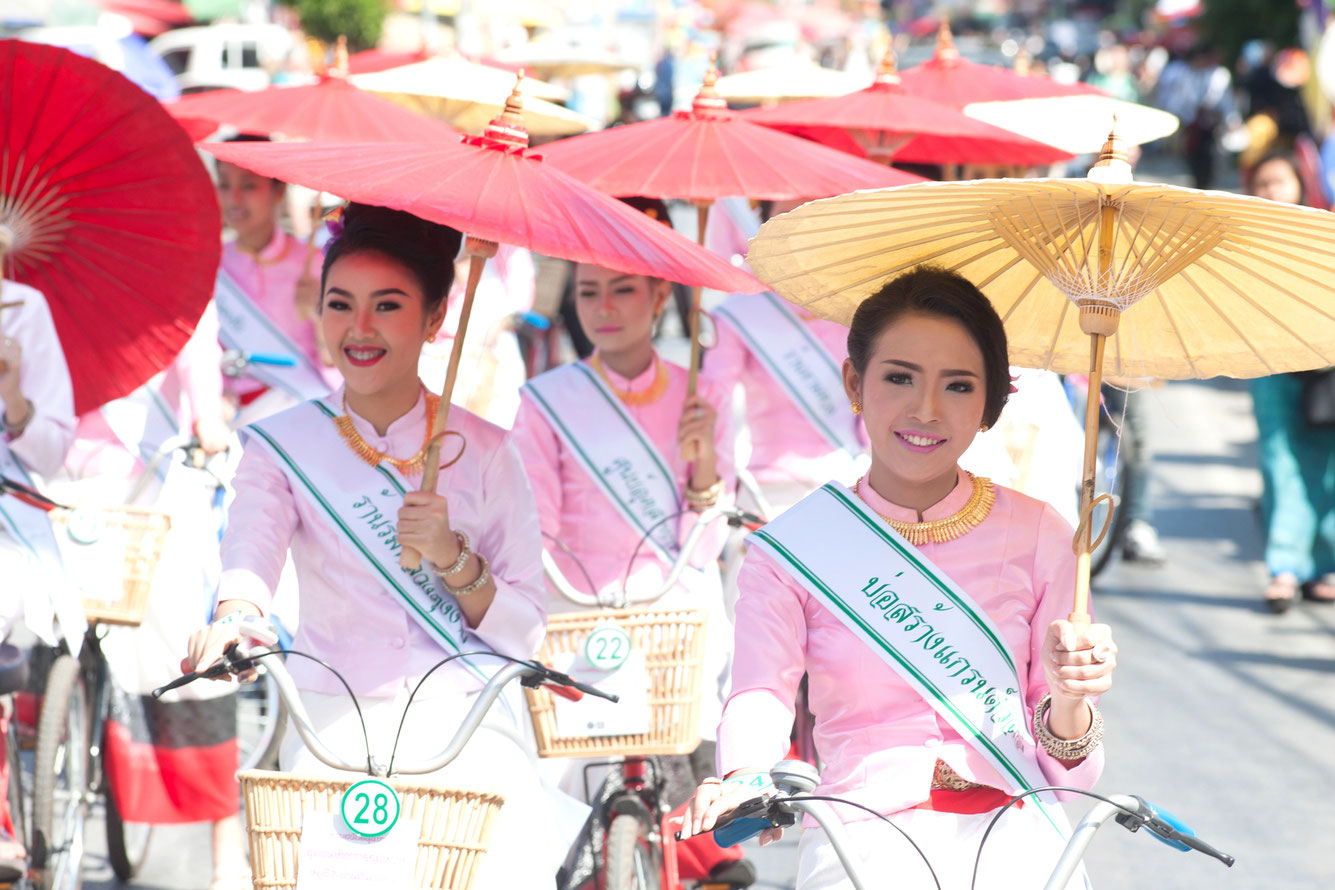 3 Thailändische Frauen im traditionellem Kostüm auf dem Fahrrad