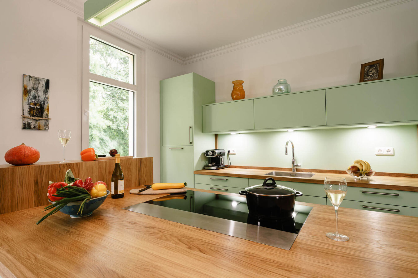 Die aus durchgängigen, handsortierten Eichenlamellen hergestellte Vollholz-Arbeitsplatte hat eine große Wirkung auf das moderne Landhausdesign dieser Küche.