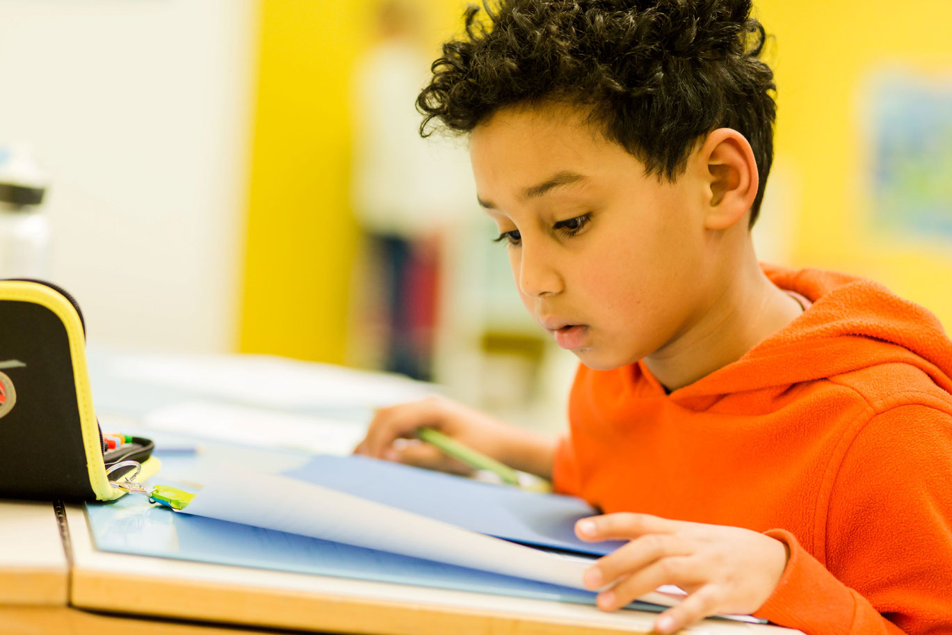 Ein Schüler der 1. Klasse bearbeitet Aufgaben im Unterricht.