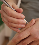 Hand mit Akupressurstab bei der Behandlung