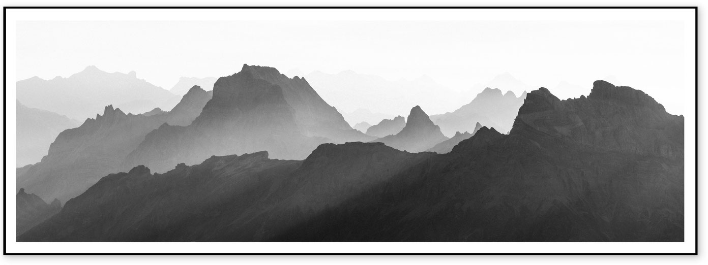 Minimal black and white panorama of layered mountain silhouettes in the western Valais Alps