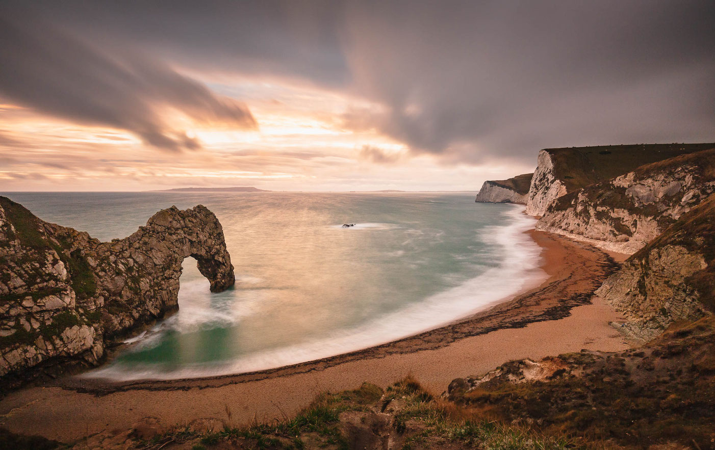 Die Landschaft Durdle Door an der Jurassic Coast in Dorset (England) bei Sonnenuntergang