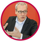 Marc Däumler, dunkles jacket, helles hemd schwarze brille und blonde haare