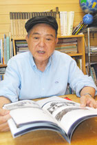 尖閣に関する資料を手にしながら、遺骨収集に懸ける思いを語る伊良皆高吉さん=20日午後、八重山日報社