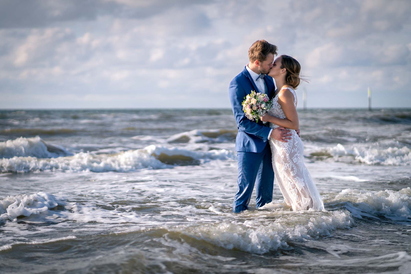 Brautpaar in der Nordsee, Brautpaar am Strand, Fotograf St Peter Ording, Hochzeitsbilder am Strand, Brautpaarshooting, Brautpaar küsst sich in der Nordsee, Trash the Dress in Sankt Peter Ording