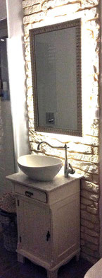 Badezimmeridee: Kleiner Waschtisch vor Steinwand im Landhausstil