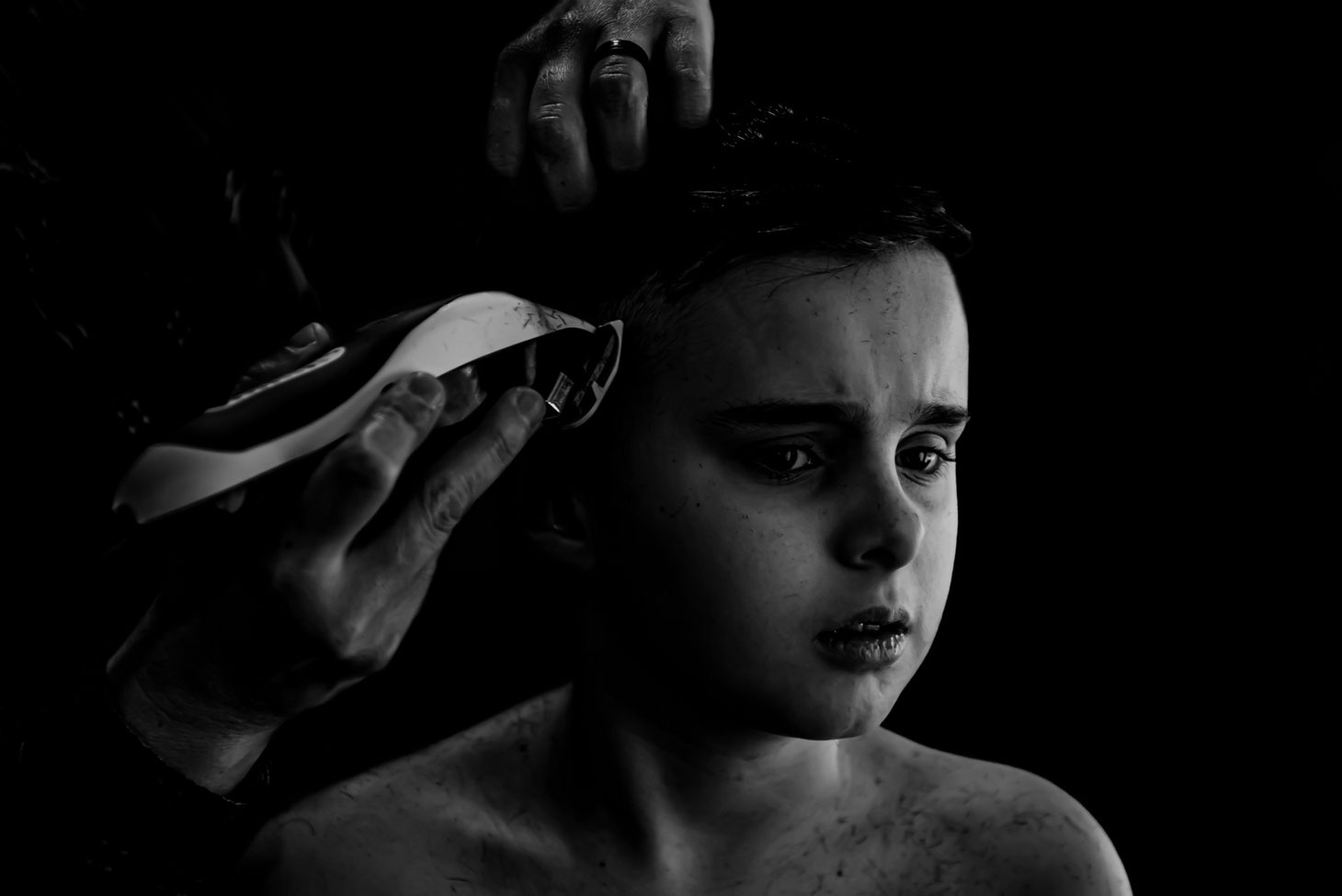 Black and white photo of mom giving child a haircut. 