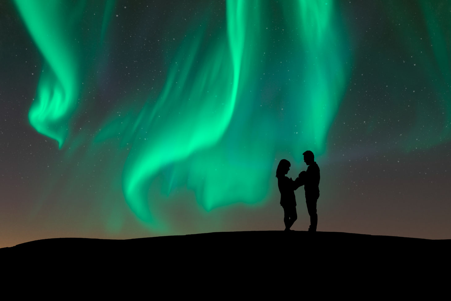 silhouette of mother, new baby, and father on a hill. Sky shows the green Northern Lights and stars. Sky is dark blue with some pink and yellow.