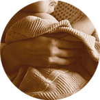 Baby eingewickelt in Wolldecke, gehalten von Frau im Strickpulli