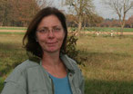 Eine Frau mit langen braunen Haaren und einer Brille.