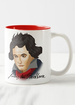 Vor weißem Hintergrund steht eine weiße Tasse mit Henkel, die innen rot ist. Auf ihr ist ein Beethoven-Porträt als Cartoon.