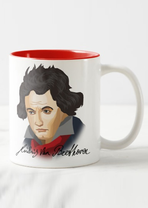 Against a white background is a white cup with a handle that is red on the inside. On it is a cartoon portrait of Beethoven.