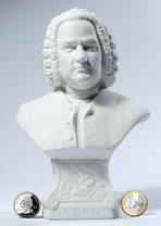 One of several Bach busts in the Bach Shop. You can see Bach's shoulders, and the actual person rests on a kind of pedestal. The bust is white, as is the background. At the bottom are two coins for a size comparison: a Euro and a US Quarter.