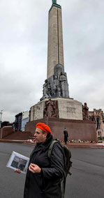 Latvian tour guide Philip Birzulis wearing an orange beret in front of Riga's Freedom Monument