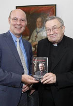 Verleger Michael Bonewitz (links) übergibt das Buch an Karl Kardinal Lehmann, der gleich interessiert darin blätterte. Foto: hbz/Jörg Henkel