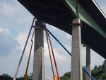 Vier Telekräne und vier- fünf Männer mit Blauhelmen unterschiedlicher Farbe montieren Stahlträger an einem Brückenpfeiler der Rader Hochbrücke