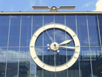 Das grosse Zifferblatt der Uhr an der Rundhofhalle der Mustermesse, zuoberst: das abstrakte MUBA-Signet