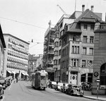 Die Spiegelgasse mit einem Tram der Linie 18, links der Spiegelhof (Polizeigebäude) und rechts das Restaurant «Meerkatz« und der ACV-Laden «Börse«, 1958