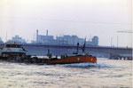Ein Tankschiff auf dem Rhein, im Hintergrund die neue Johanniterbrücke und der St.Johann-Hafen, 1967