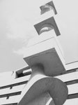 Die acht Meter hohe Stele (Säule) von Hans Arp im Pausenhof der Gewerbeschule Basel (im Hintergrund), errichtet 1961